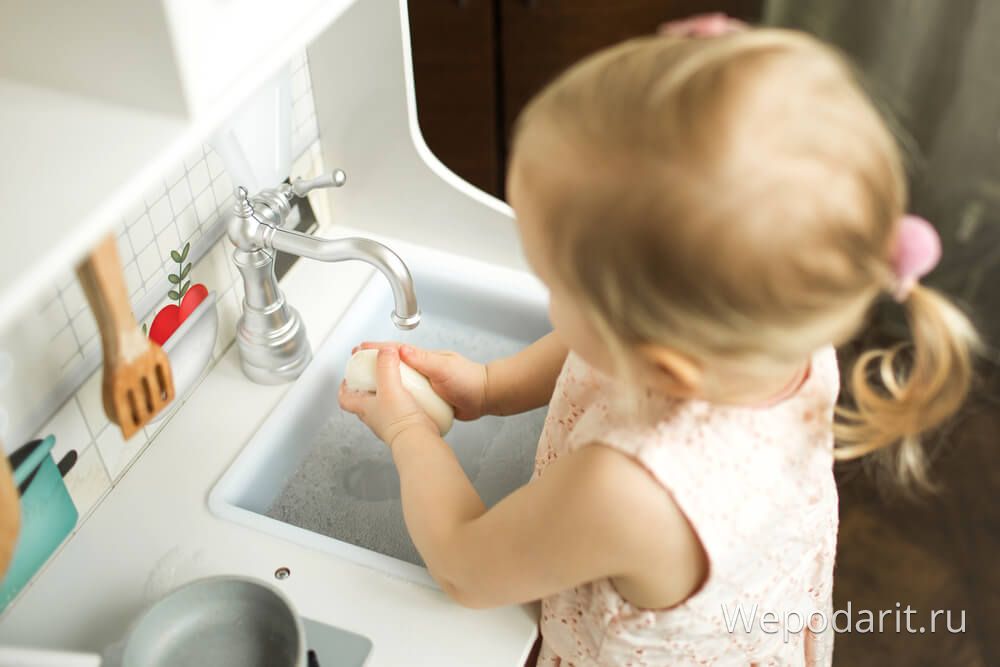 дівчинка 2 роки миє руки на іграшковій кухні