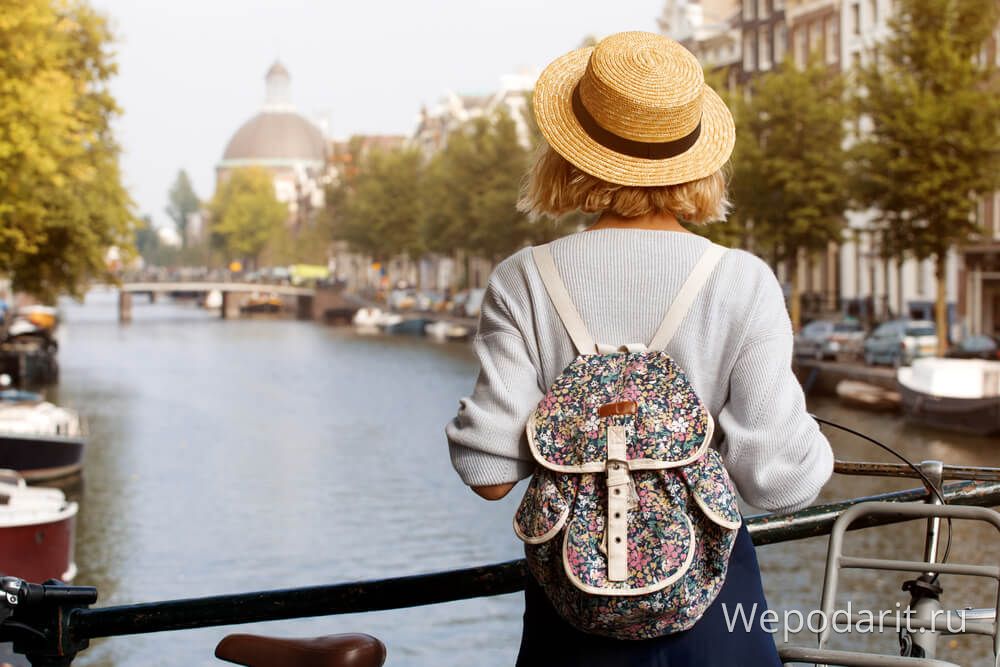 дівчина з квітковим рюкзаком в Амстердамі