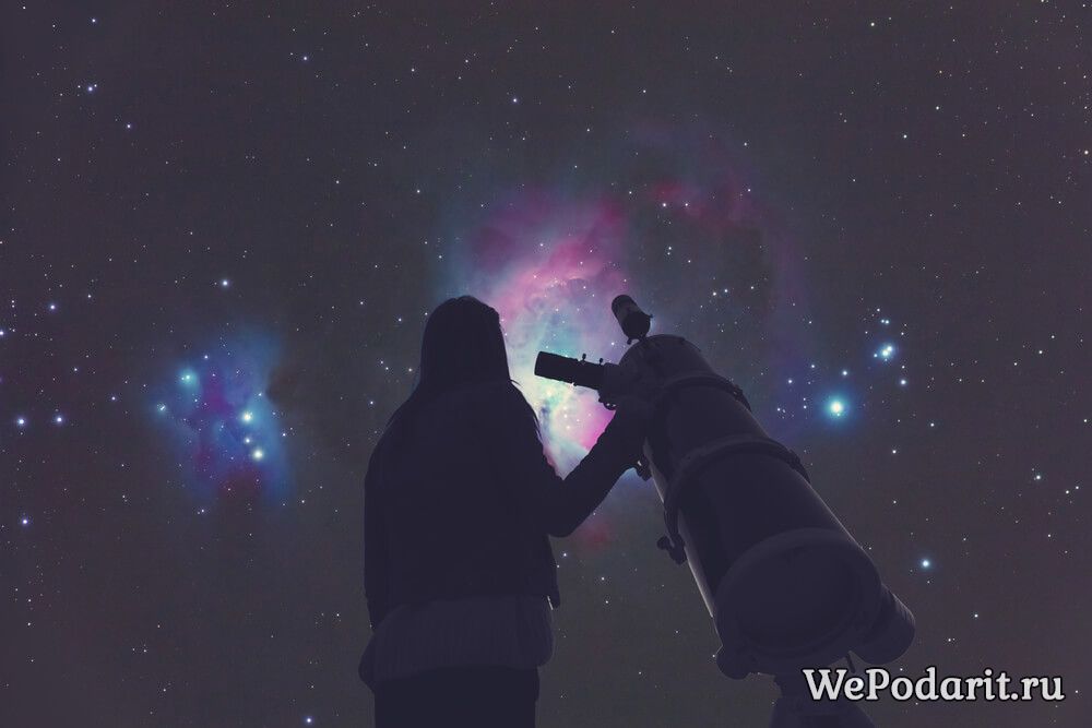 дівчина дивиться в космос через телескоп