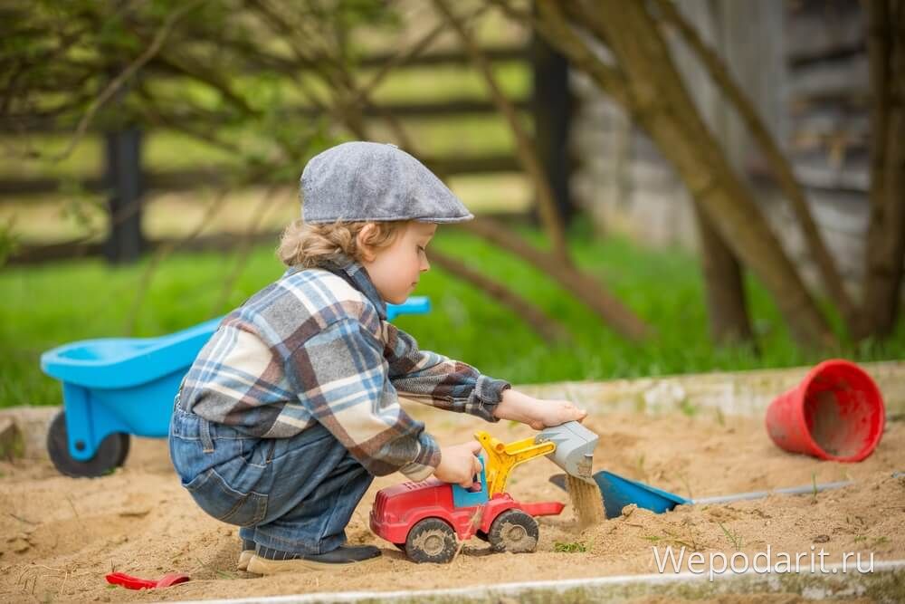 хлопчик 2 роки грає в пісочниці