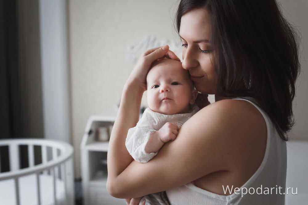 мама тримаємо свою новонароджену дитину на руках