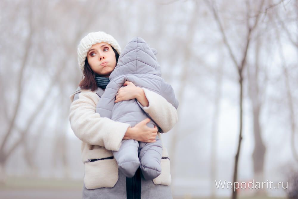 мама з дитиною на руках на зимовій прогулянці
